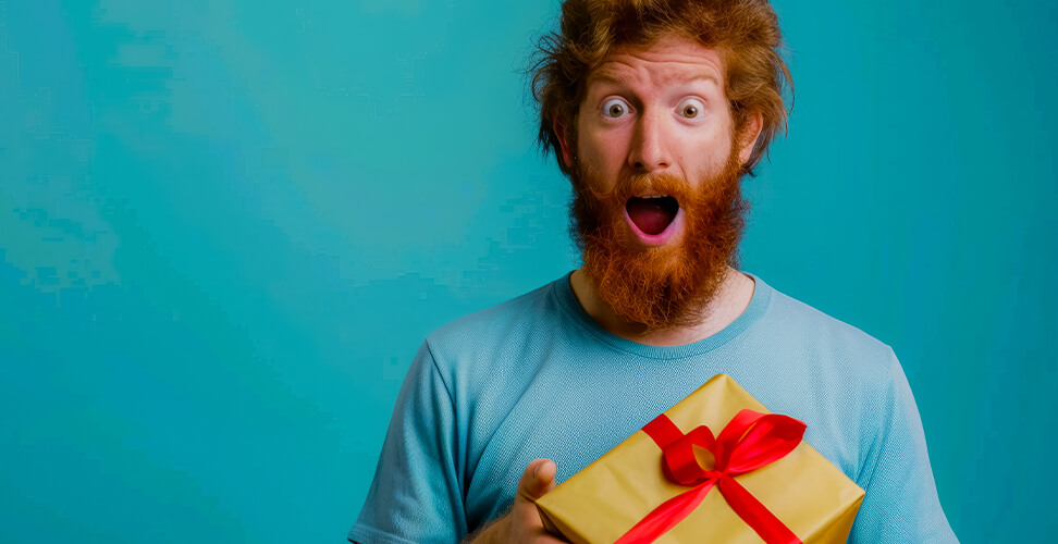 Man holding a gift with shocked and surprised expression &ndash; perfect reaction for funny, surprising, or novelty Christmas and birthday presents