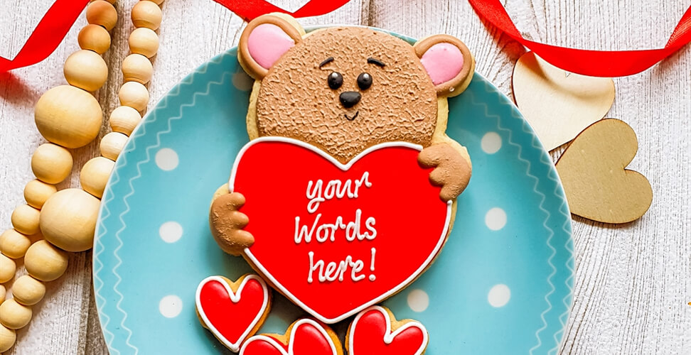 Teddy bear cookie on polka dot plate holding heart &ndash; customisable cookie with your own message, perfect personalised gift treat