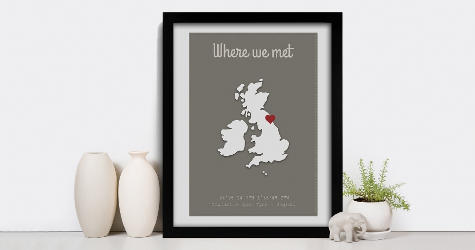A framed print displaying a map of the UK with a red heart marking Newcastle, accompanied by minimalist decor.