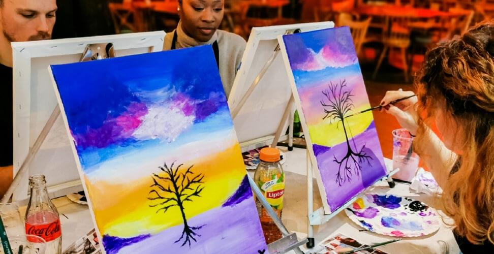Group enjoying a sip and paint experience – fun painting class with drinks, creative social activity, and art workshop event