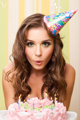 Girl blowing out the candles on her birthday cake