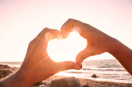 Boy and girl making a heart shape with their hands